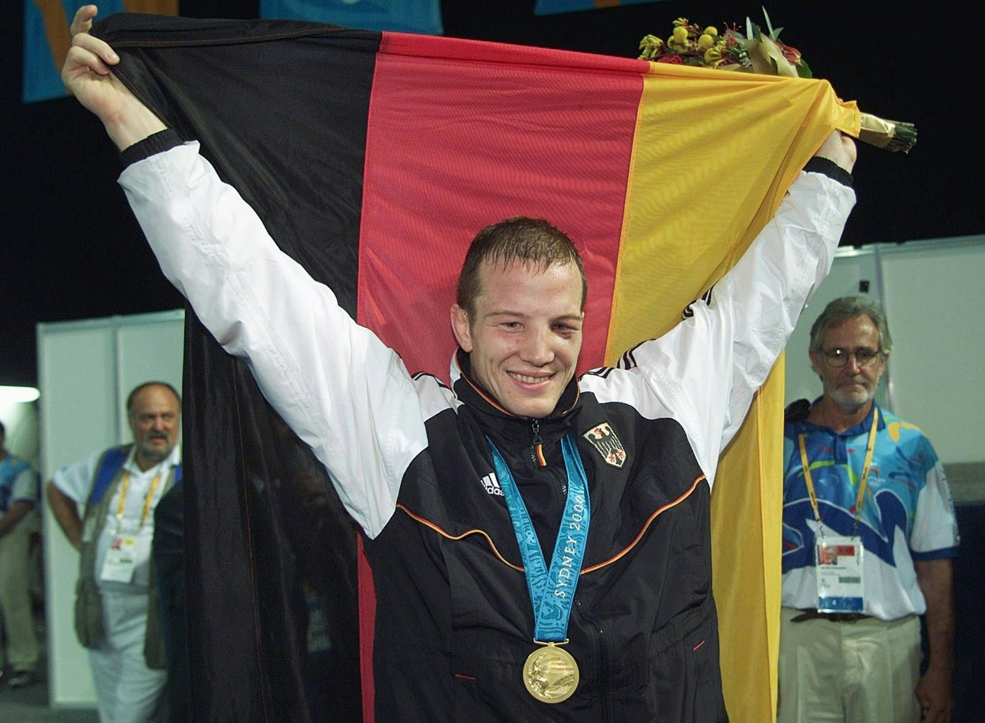 Alexander Leipold jubelt mit der deutschen Fahne nach seinem Olympiasieg.