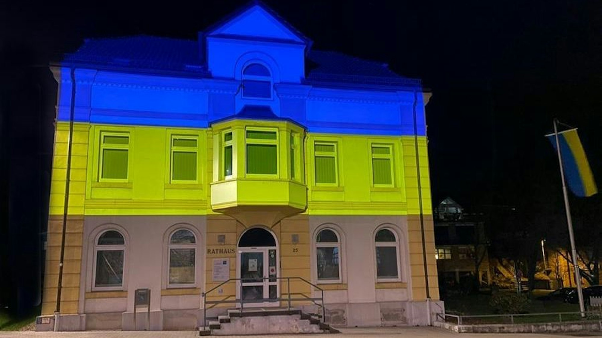 Ukraine-Krieg Das Overather Rathaus ist in Blau und Gelb angestrahlt.