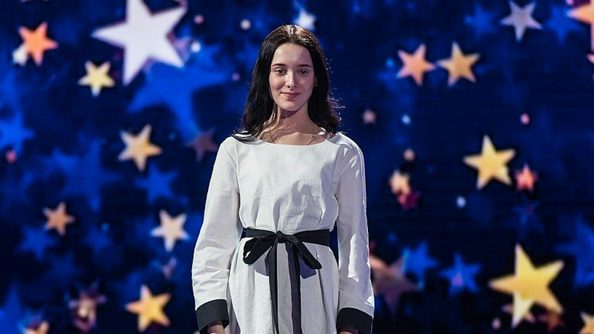 Eden Golan steht auf der Bühne, mit Sternenhimmel im Hintergrund.