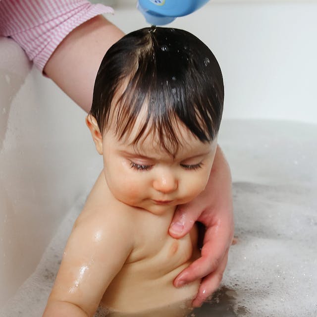 Ein Kleinkind sitzt in einer Badewanne