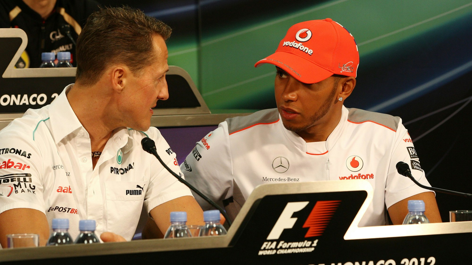 Michael Schumacher (l.) und Lewis Hamilton unterhalten sich auf einer Pressekonferenz.