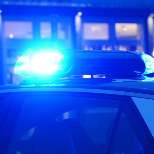 Ein Blaulicht leuchtet auf dem Dach eines Polizeiautos während einer Polizeiabsperrung.