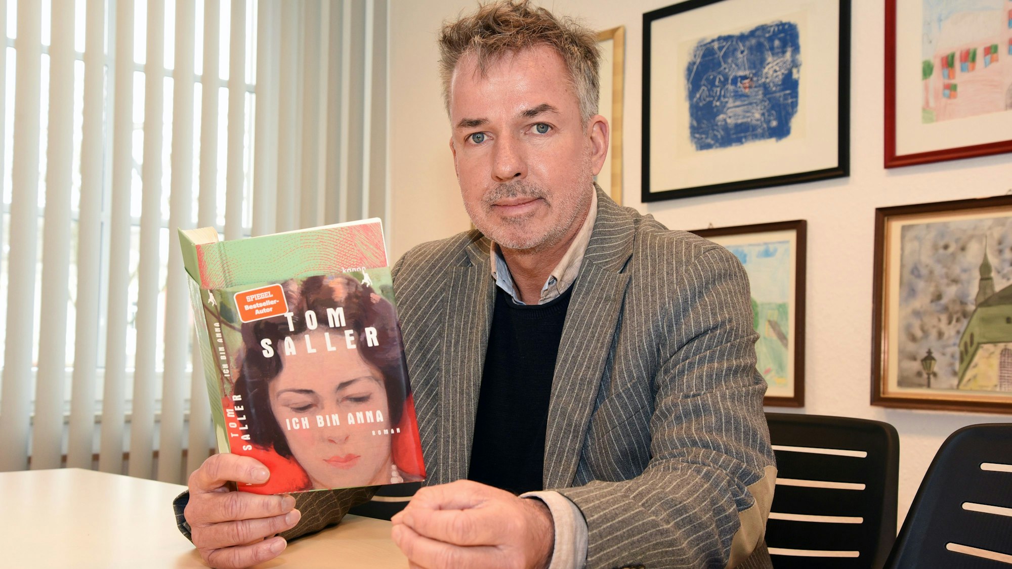 Das Foto zeigt den Wipperfürther Autor Tom Saller, in der Hand hält er seinen neuen Roman "Ich bin Anna".