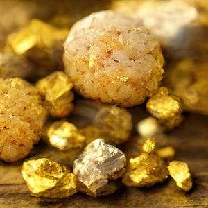 Goldene Steine und Kristalle liegen nebeneinander. (Symbolbild)
