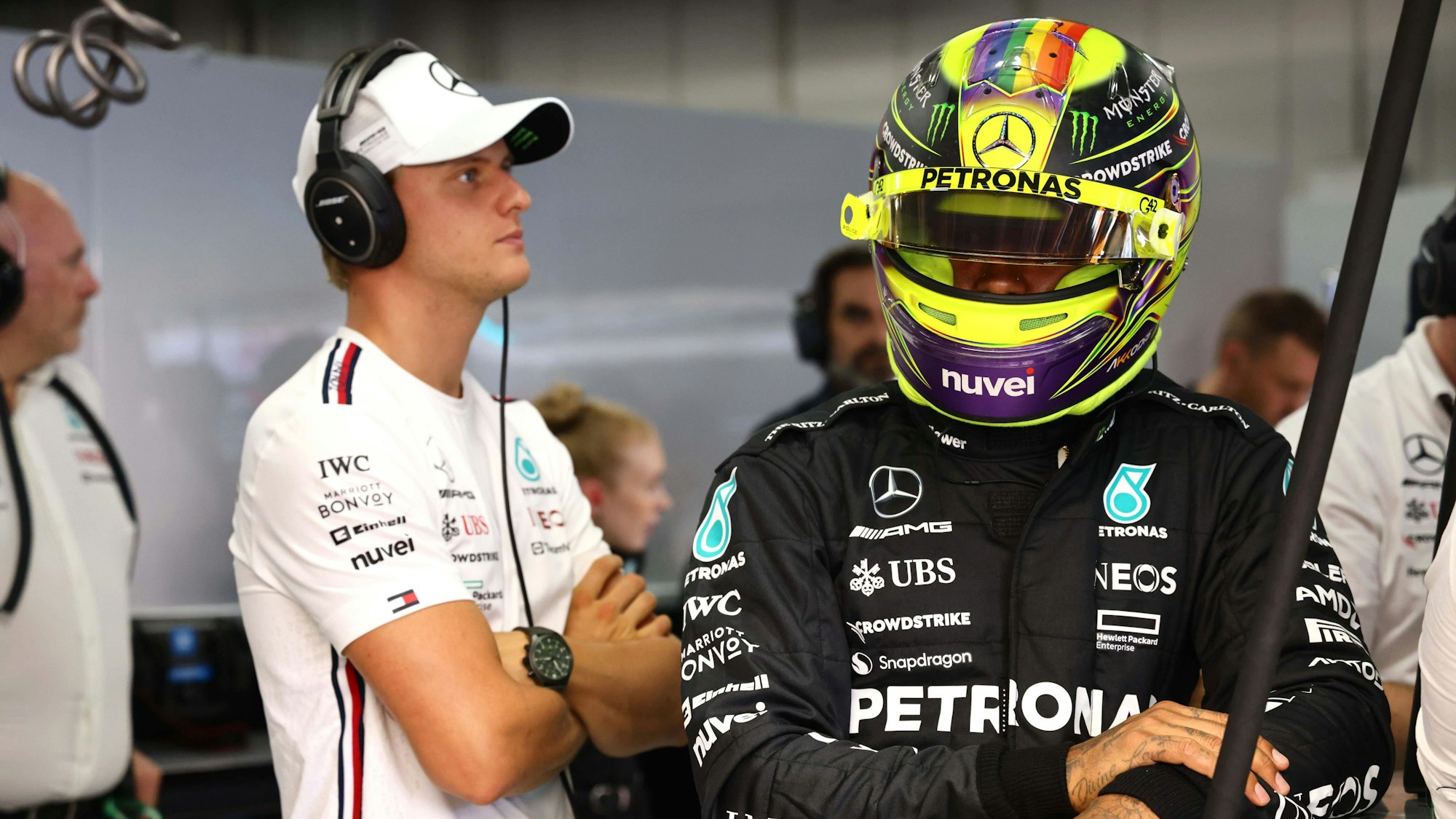 Mick Schumacher und Lewis Hamilton stehen bei einem Rennen der Formel 1 in der Box von Mercedes.