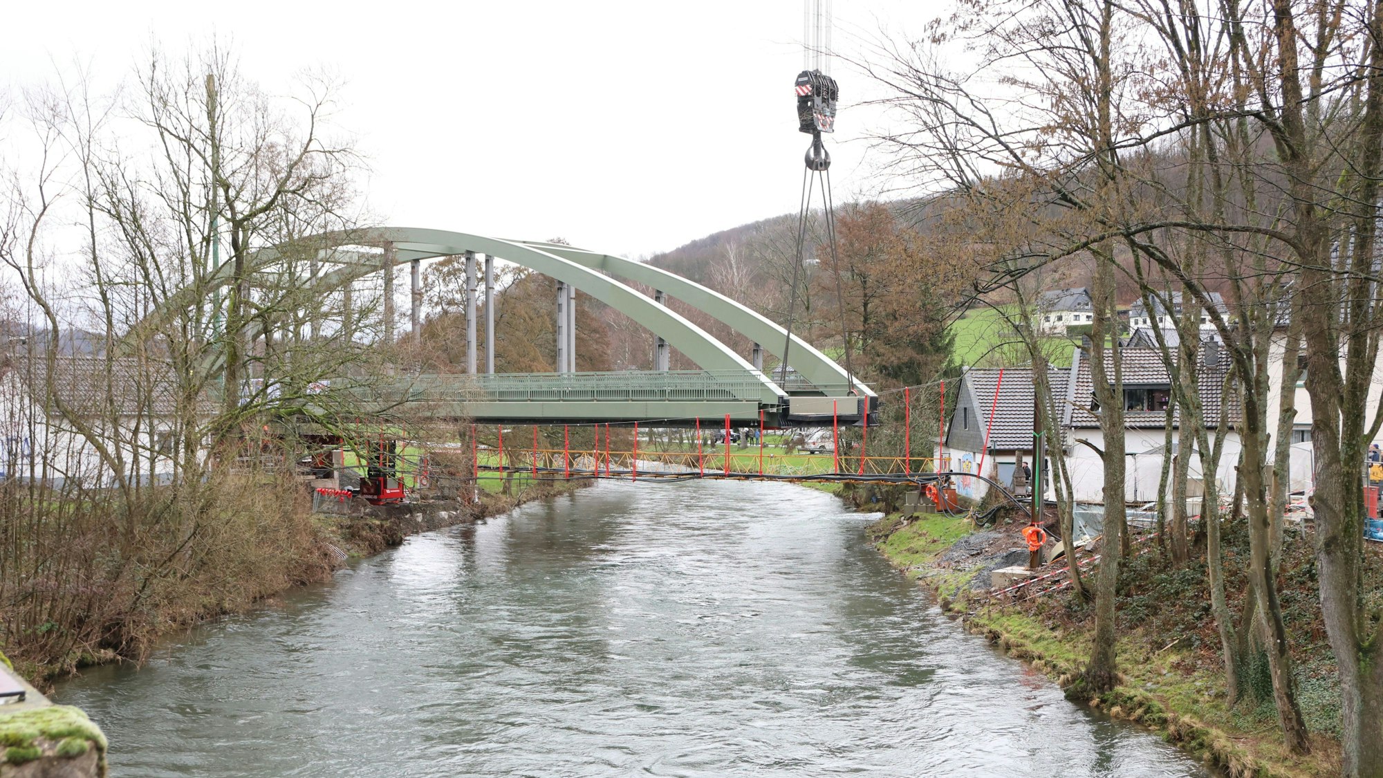 Eine Stahlbrücke mit Bogen über einem Fluss.