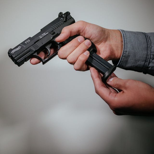 Ein Mann lädt eine Schreckschuss-Pistole mit einem Magazin