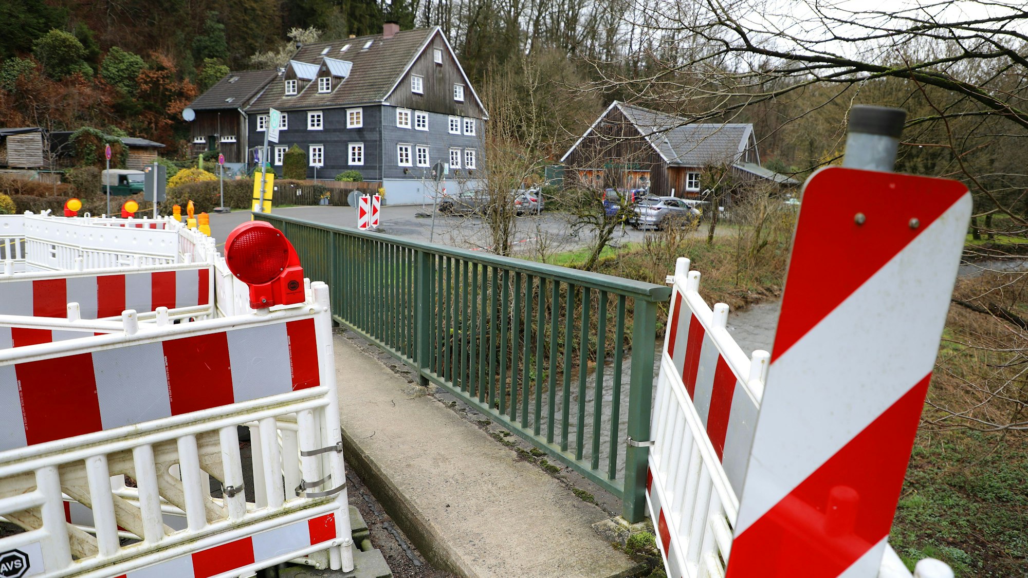 Warnbaken stehen auf einer gesperrten Straßenbrücke im Eifgenbachtal.