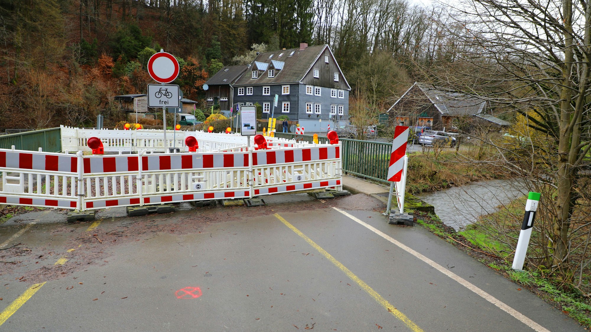 Warnbaken sperren die Straßenbrücke in Wermelskirchen-Neumühle über den Eifgenbach.
