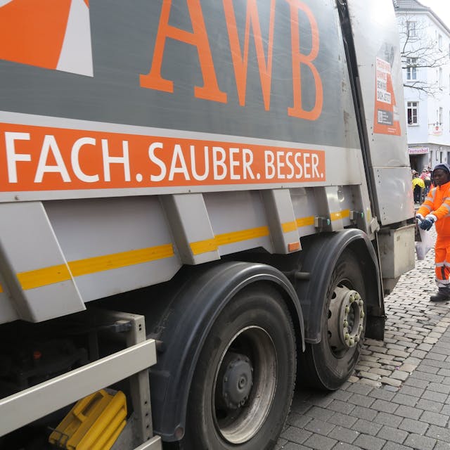 Ein Müllwagen der Abfallwirtschaftsbetriebe Köln steht auf einer Straße.