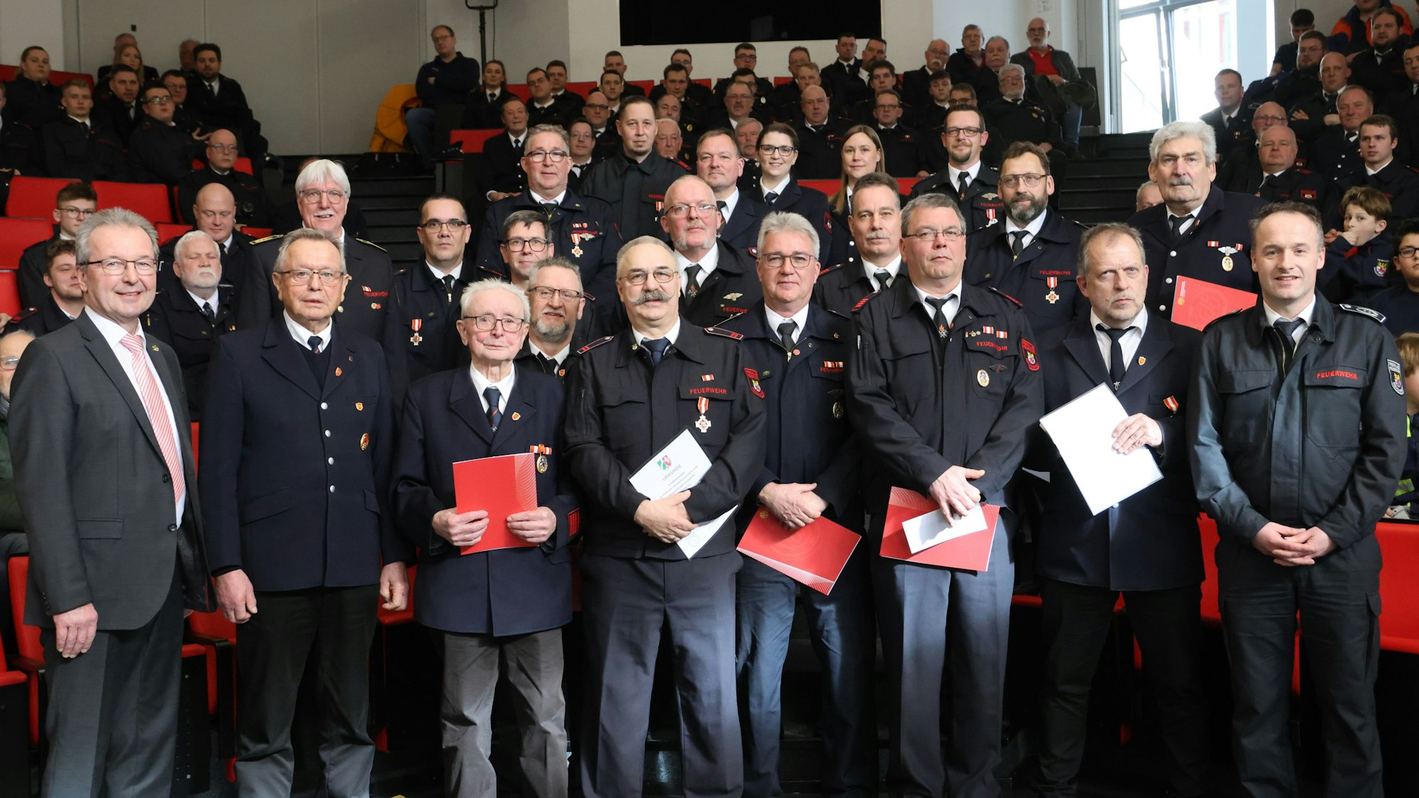Das Foto zeigt die Feuerwehrleute aus Reichshof, die im Rahmen der Jahresdienstbesprechung geehrt wurden, dazu Bürgermeister Rüdiger Gennies (l.) und Sascha Frede (r.).