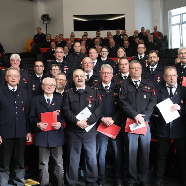 Das Foto zeigt die Feuerwehrleute aus Reichshof, die im Rahmen der Jahresdienstbesprechung geehrt wurden, dazu Bürgermeister Rüdiger Gennies (l.) und Sascha Frede (r.).