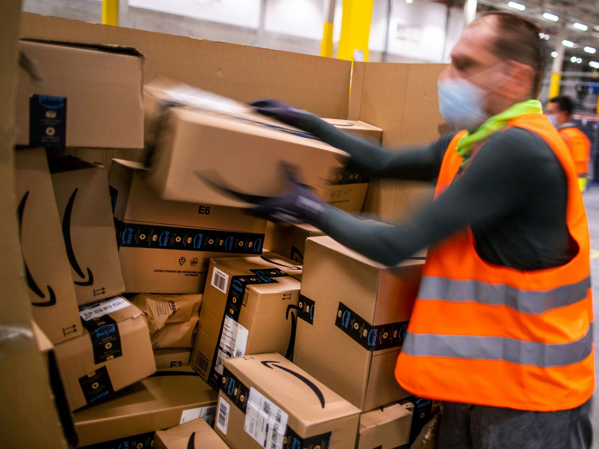 Ein Mitarbeiter sortiert an einem Transportband Paketsendungen in einem Verteilzentrum des Online-Händlers Amazon.