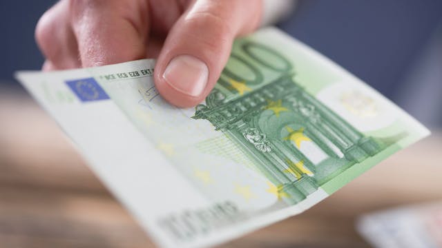 Eine Person hält einen 100-Euro-Schein in der Hand