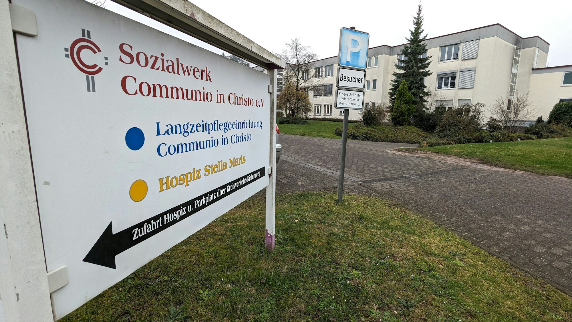 Neben einem Schild des Sozialwerks Communio in Christo e.V. in Mechernich ist das Pflegeheim zu sehen, das der Verein dort betreibt.