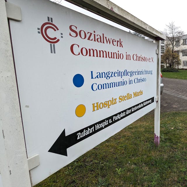 Neben einem Schild des Sozialwerks Communio in Christo e.V. in Mechernich ist das Pflegeheim zu sehen, das der Verein dort betreibt.