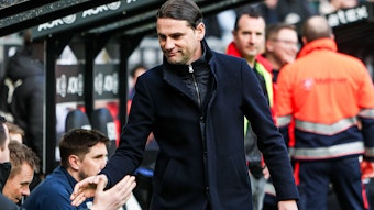 Trainer von Borussia Mönchengladbach klatscht mit der Trainerbank ab.