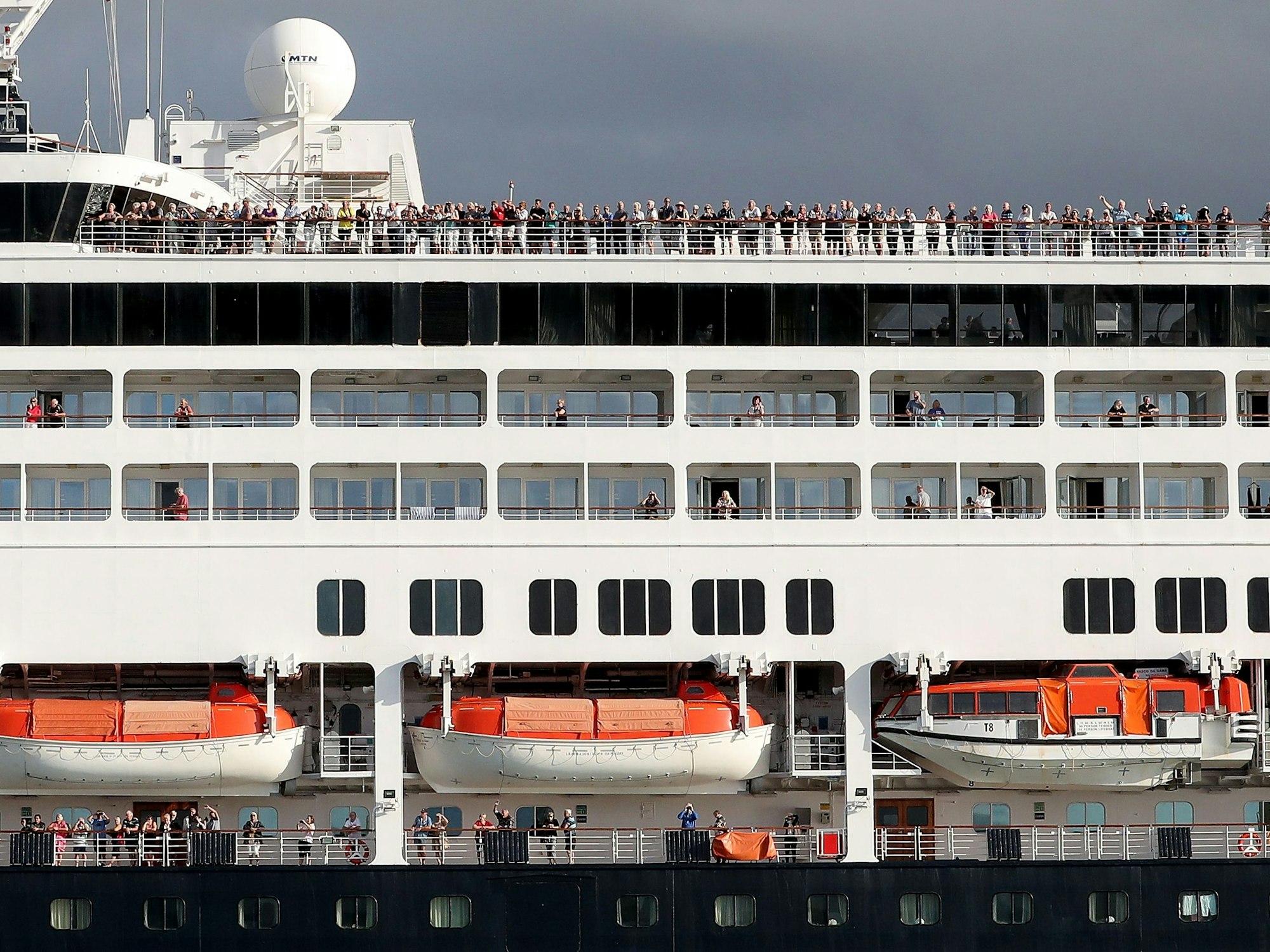 Passagiere und Passagierinnen stehen auf dem Deck des Kreuzfahrtschiffes „Vasco da Gama“ bei der Ankunft im Hafen von Fremantle, hier im März 2020.