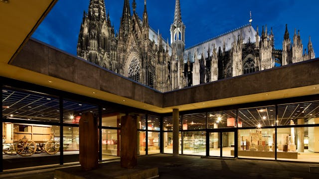 Über dem Atrium des Kölner Römisch-Germanischen Museums erhebt sich der angestrahlte Dom.