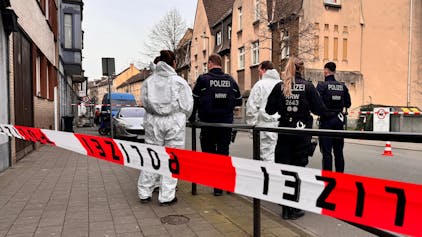 Beamte stehen an dem abgesperrten Tatort in Duisburg.