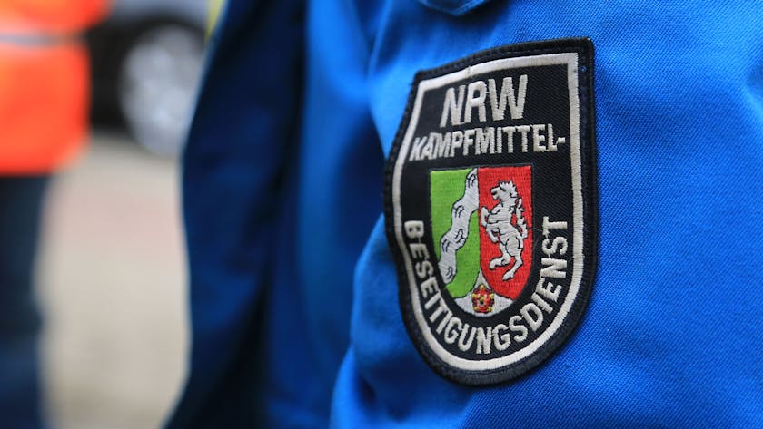 Ein Wappen mit der Aufschrift „NRW-Kampfmittel-Beseitigungsdienst“ ist auf einer Jacke aufgenäht.