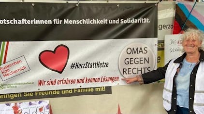 Walli Forner vor einem Plakat der Bürgerinitiative „Omas gegen Rechts“.
