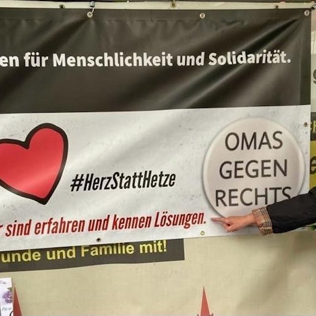 Walli Forner vor einem Plakat der Bürgerinitiative „Omas gegen Rechts“.