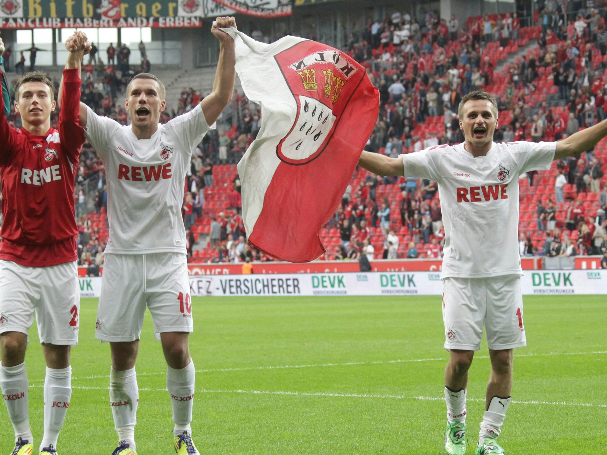 Adam Matuschyk, Lukas Podolski und Slawomir Peszko (v.l., 1. FC Köln) mit Köln-Fahne in Leverkusen.