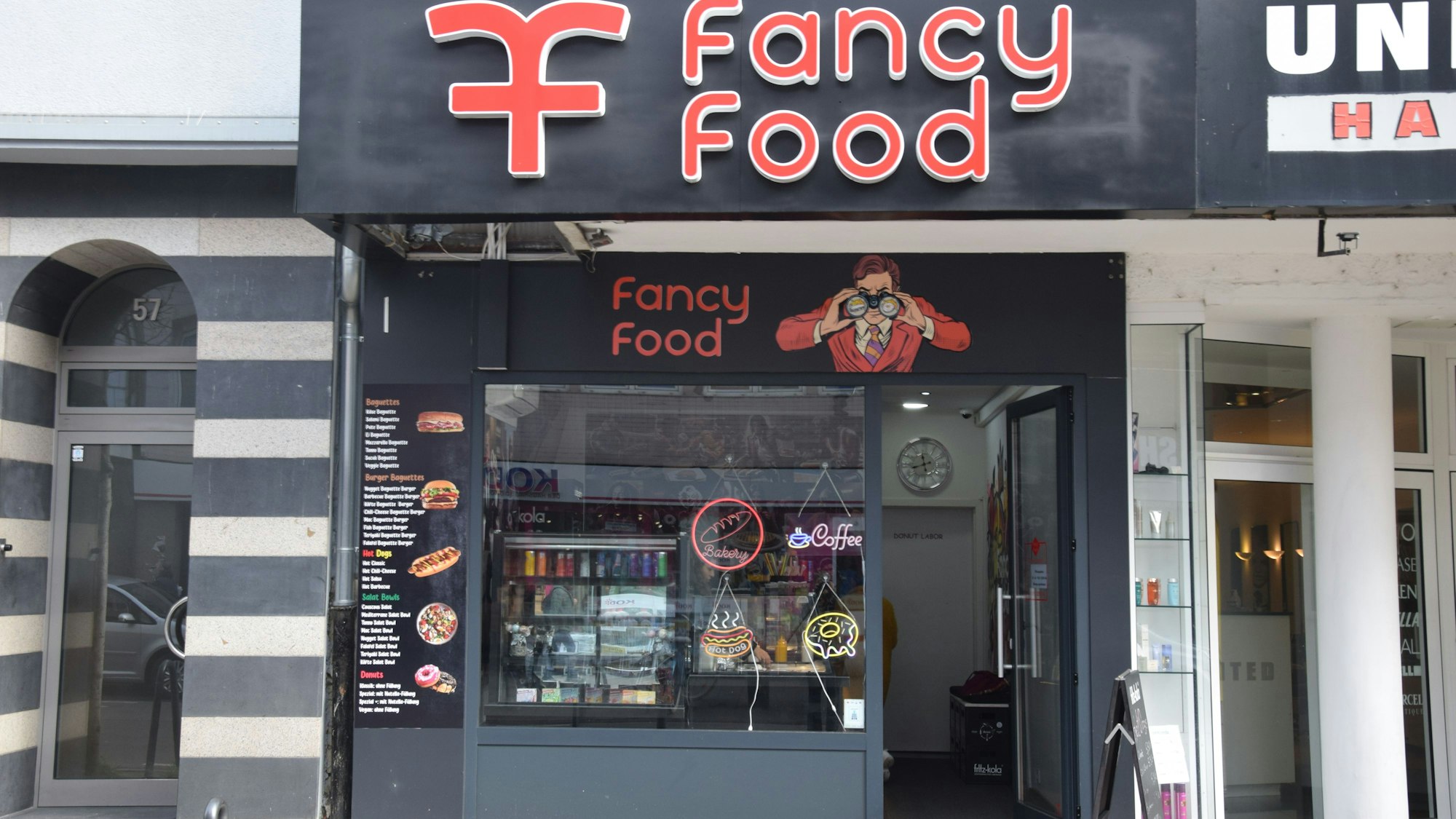 Die Front eines Fast-Food-Ladens mit dem Namen Fancy Food ist zu sehen.