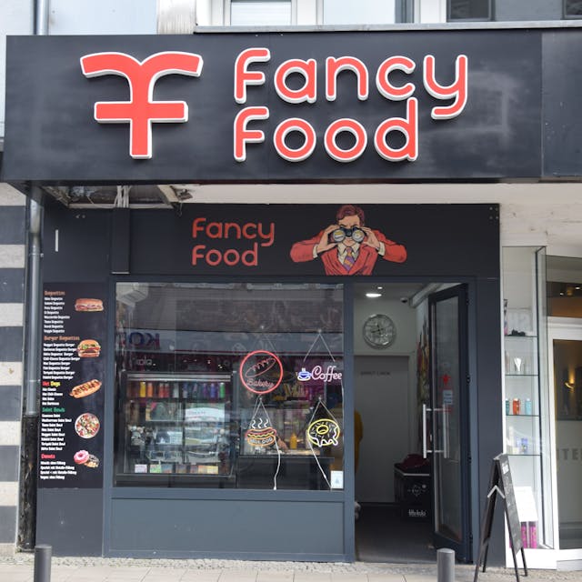 Die Front eines Fast-Food-Ladens mit dem Namen Fancy Food ist zu sehen.