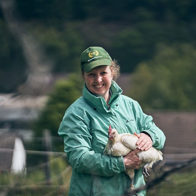 Landwirtin Susanne Schulte mit einem Huhn auf dem Arm
