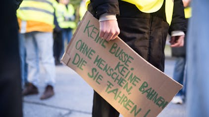 Luisa Neubauer, Aktivistin von Fridays for Future, hält am BVG-Busdepot Cicerostraße ein Schild mit der Aufschrift «keine Busse, keine Bahnen, ohne Menschen, die sie fahren!» in der Hand.