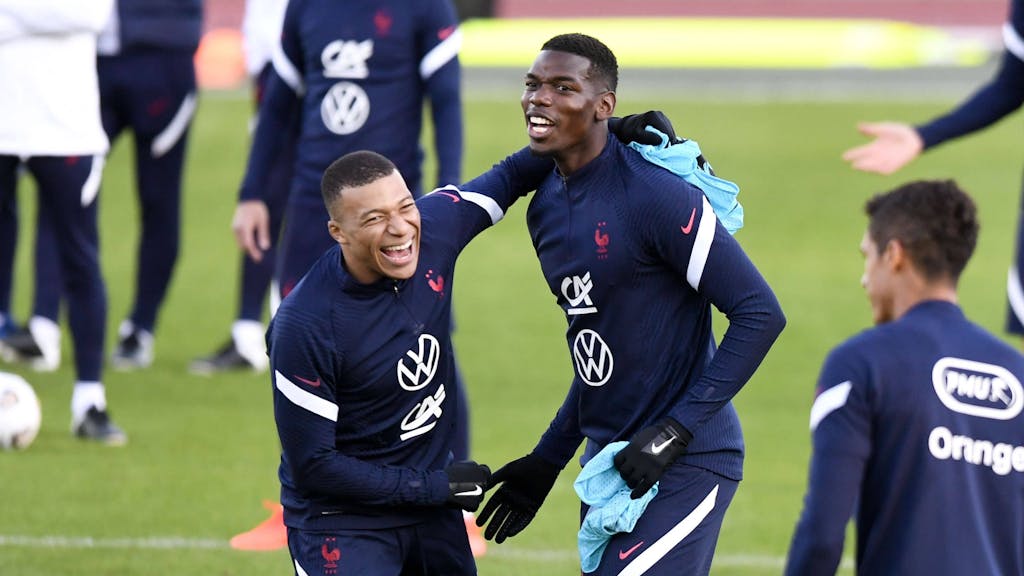 Paul Pogba lacht mit seinem Nationalmannschaftskollegen Kylian Mbappe.
