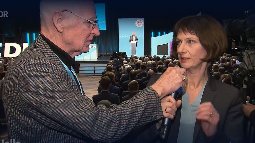 Bei einer CDU-Regionalkonferenz greift ein Mann NDR-Reporterin Katharina Seiler ins Mikrofon.