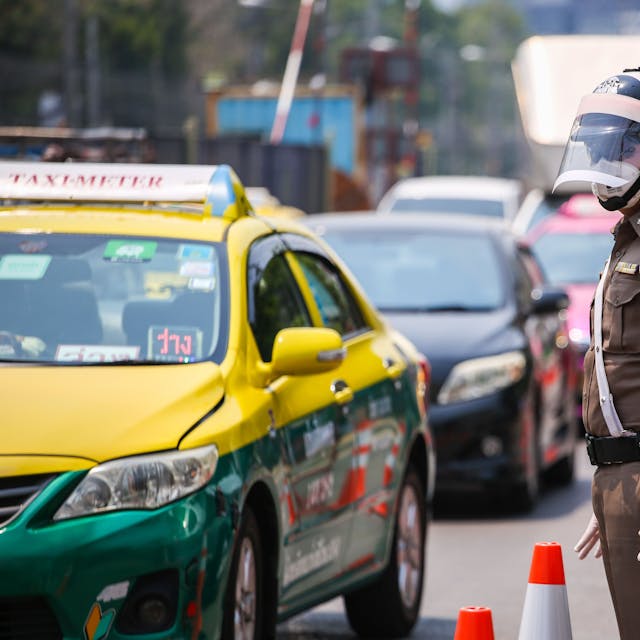 Ein thailändischer Polizist steht im Straßenverkehr. Bei einem Verkehrsunfall sind zwei Stiefbrüder aus Düsseldorf getötet worden. (Symbolbild)