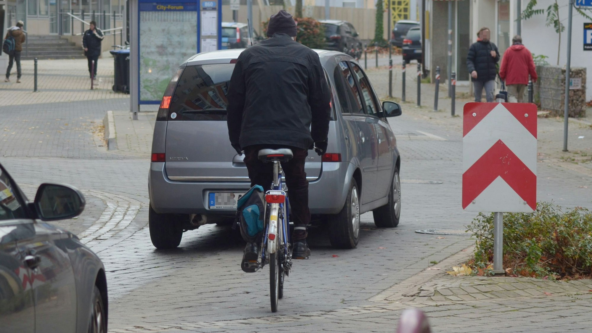 Das Bild zeigt einen Radfahrer in der Euskirchener Innenstadt. Vor und hinter ihm fahren Autos.