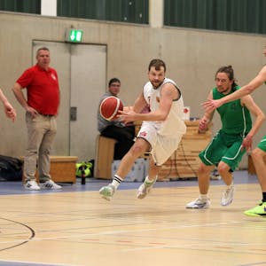 Basketballer Philipp Greuel läuft mit dem Ball, um ihn herum sind drei&nbsp; Gegenspieler.