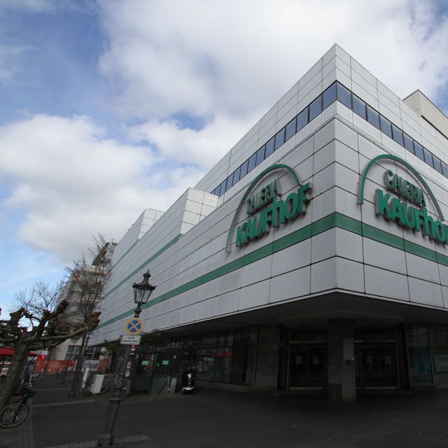 Ein leer stehendes Kaufhof-Gebäude mit weißer Fassade und grüner Reklameschrift