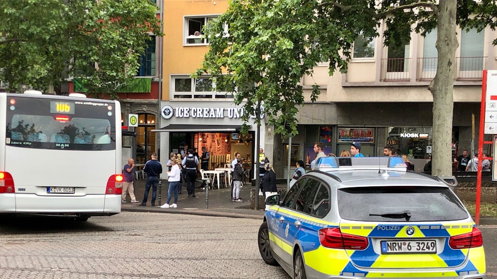Foto eines Polizeieinsatzes in Köln, daneben ist ein weißer Bus zu sehen.
