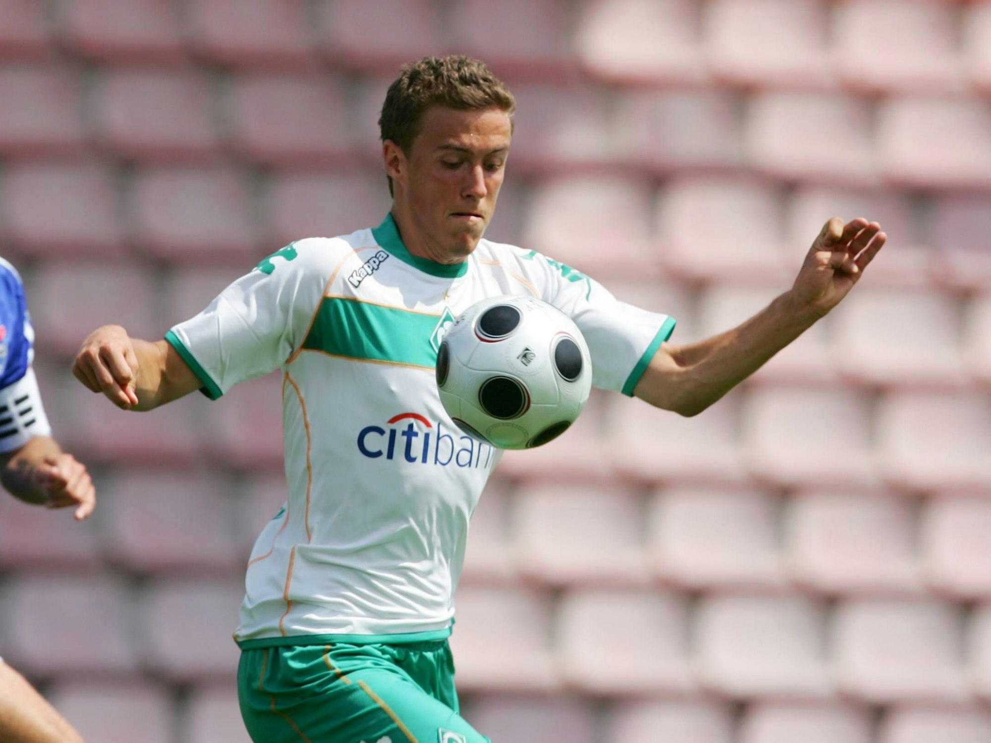 Ein junger Max Kruse im Trikot von Werder Bremen mit seinem Blick auf den Ball gerichtet.