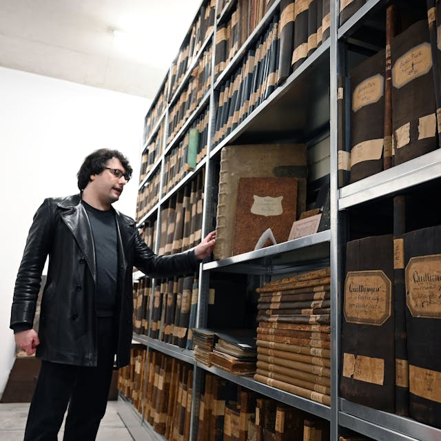 Juliano de Assis Mendonça zeigt im Depot der Vereinigten Adelsarchive im Rheinland ein Buch aus dem 18. Jahrhundert.&nbsp;