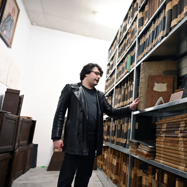 Juliano de Assis Mendonça zeigt im Depot der Vereinigten Adelsarchive im Rheinland ein Buch aus dem 18. Jahrhundert.&nbsp;