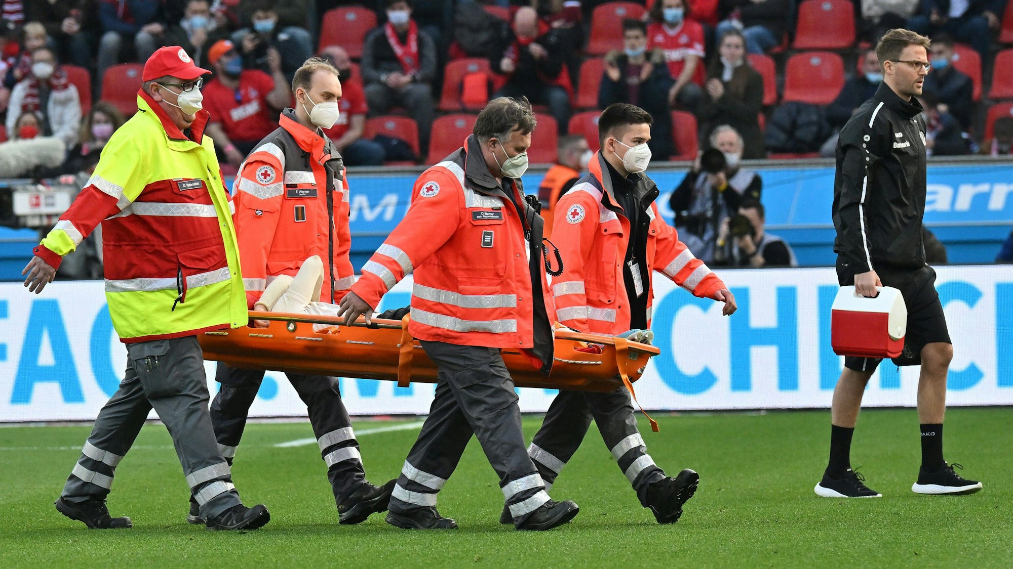 Florian Wirtz wird verletzt, unter Anfeindungen einiger Köln-Fans, aus dem Stadion getragen