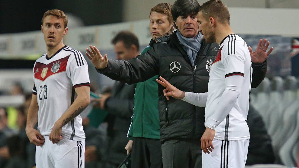 Lukas Podolski erhält vor seiner Einwechslung von Joachim Löw letzte Anweisungen. Max Kruse schaut interessiert zu.