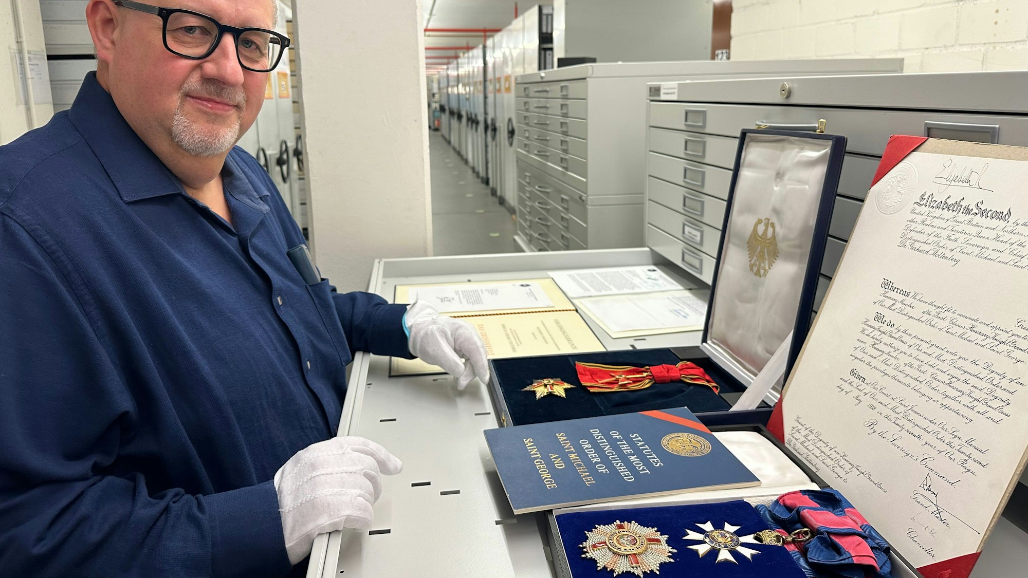 Michael Hansmann, Leiter Schriftgutarchiv, zeigt Orden, die Gerhard Stoltenberg verliehen wurden.