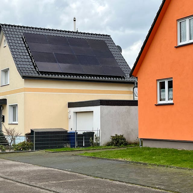 Fotovoltaik-Panele sind auf einem Hausdach montiert.