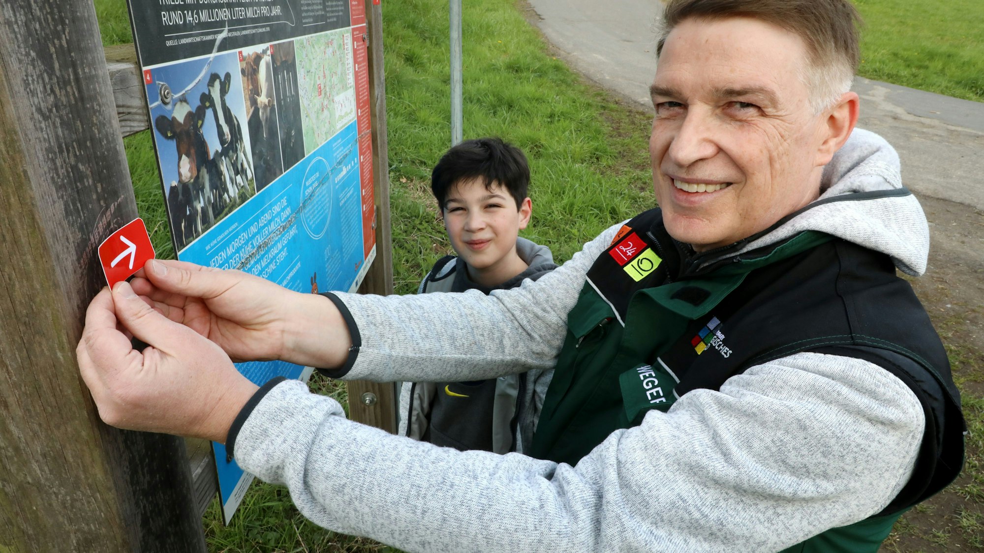 Dr. Erik Werdel, und Sohn Maximilian beim Wegemarkieren auf dem Bauernhofweg bei Lohmar.