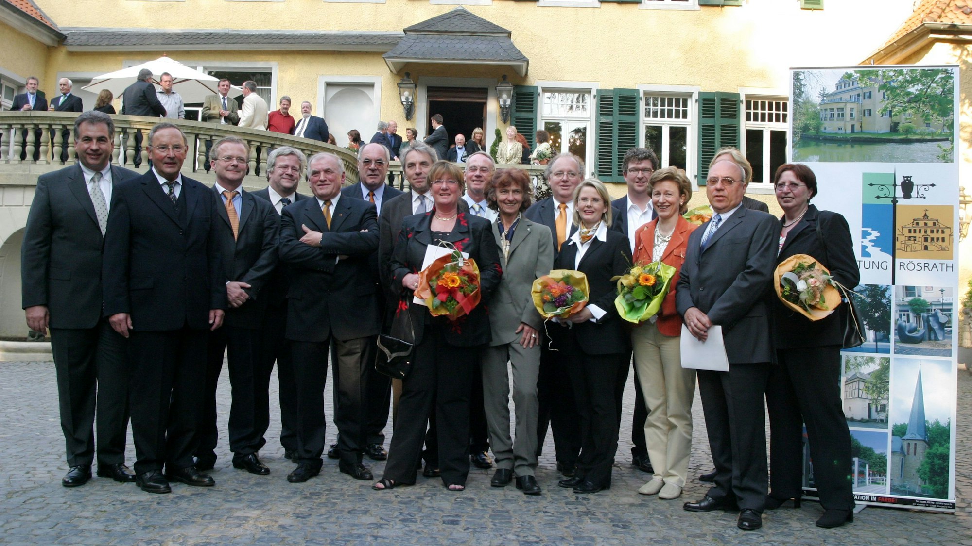 Bürgermeister Dieter Happ und Regierungspräsident Jürgen Roters stehen im Jahr 2004 mit den Gründungsstiftern und Aktiven der Bürgerstiftung Rösrath im Hof von Schloss Eulenbroich.
