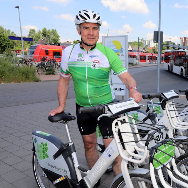 Werner Schneider parkt ein E-Bike an einer Fahrradstation.