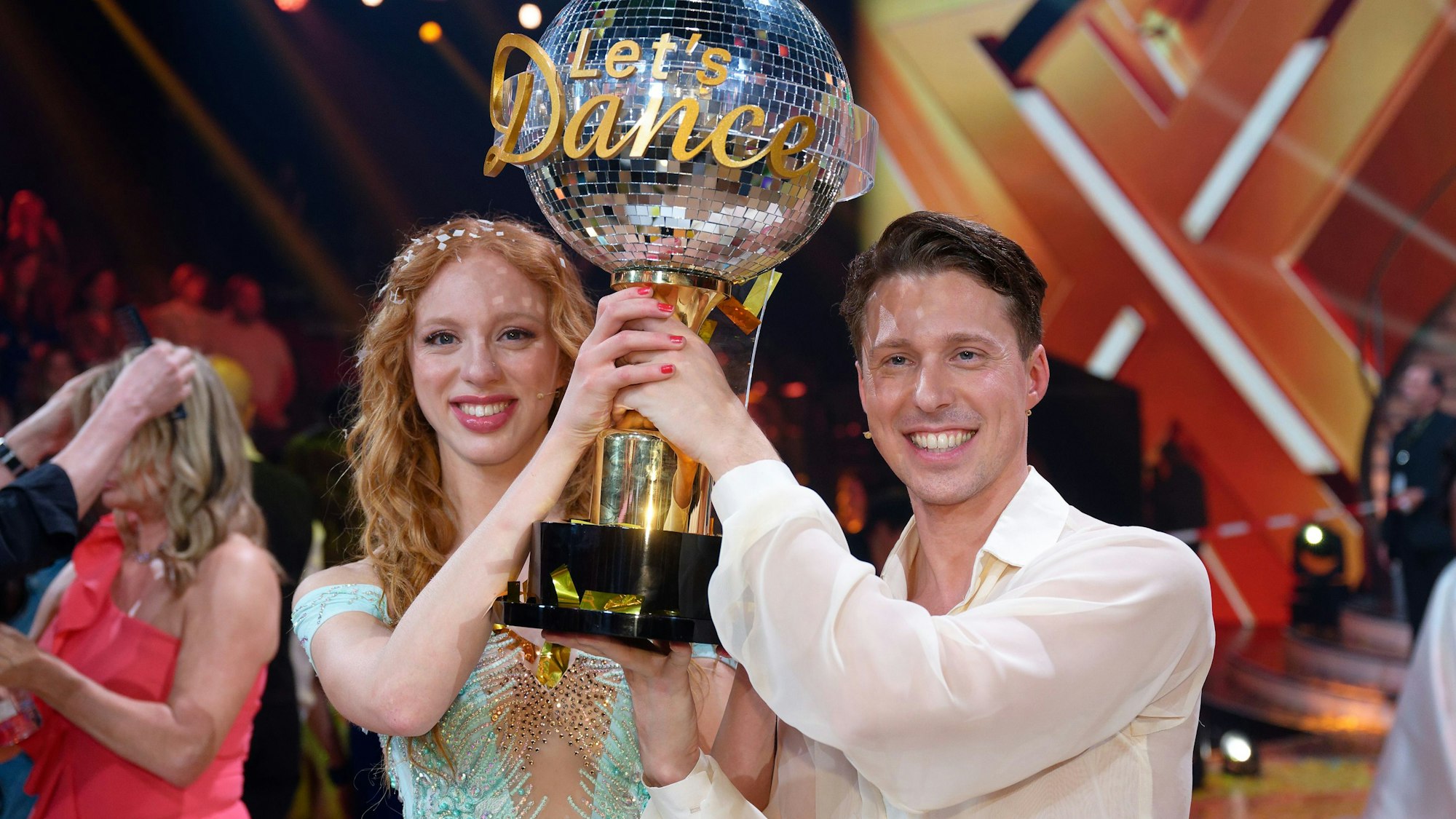 Model Anna Ermakova und ihr Profi-Tanzpartner Valentin Lusin jubeln über ihren Sieg mit der Trophäe nach dem Finale der RTL Live-Tanzshow „Let's Dance“, hier im Mai 2023 in Köln.